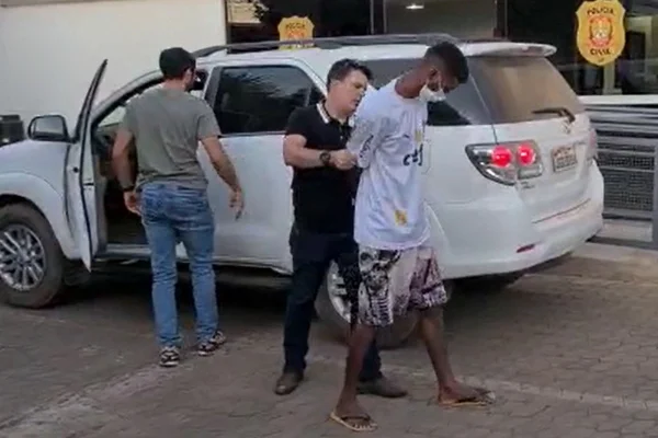 homem de camiseta algemado é conduzido por agente
