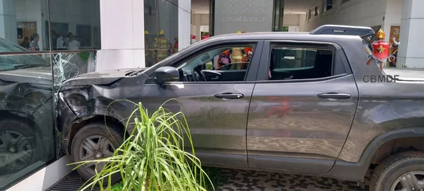 Imagem colorida de uma caminhonete cinza batida contra uma vidraça - Metrópoles