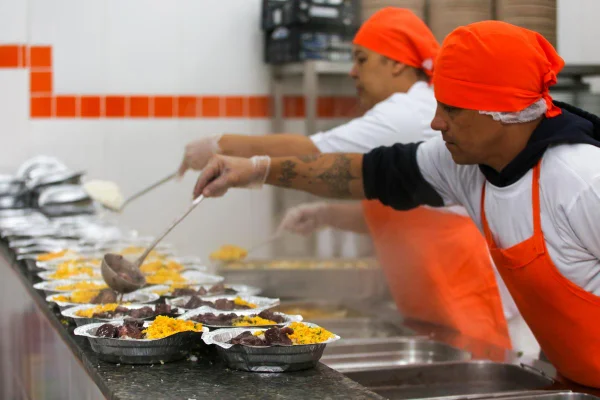 Cozinheiro montando refeição em restaurante do programa social Bom Prato - Metrópoles
