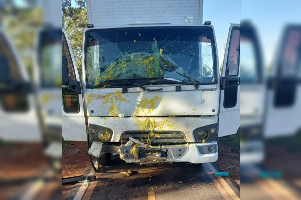 Imagem de um caminhão branco deteriorado e com marcas amarelas causadas por pamonhas na dianteira, após o veículo atingir um carrinho de pamonhas