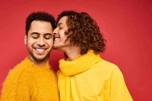 Imagem colorida de casal vestidos de amarelo com fundo vermelho
