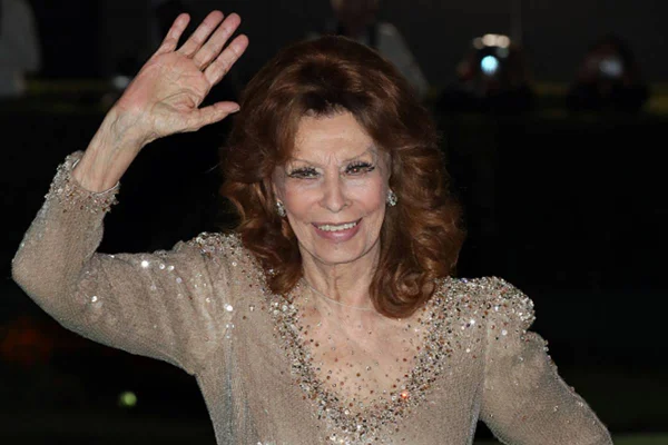 Foto colorida de Sophia Loren de braços levantados - Metrópoles