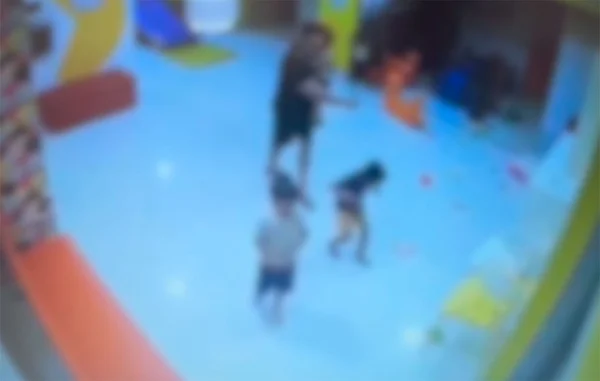 Imagem colorida borrada de câmera de segurança de mulher agredindo criança autista