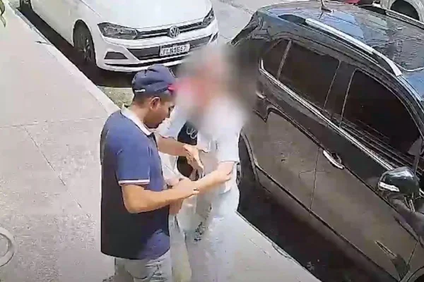 Imagem colorida de câmera seguraça mostra ladrão dando bote e roubando relógio em mulher durante assalto - Metrópoles