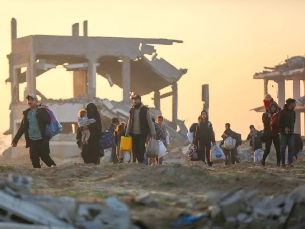 Dezenas de milhares de palestinos, deslocados pelas forças israelenses, retornam para suas casas pela rua Al-Rashid, na faixa costeira, após o acordo de cessar-fogo na cidade de Gaza - Metrópoles