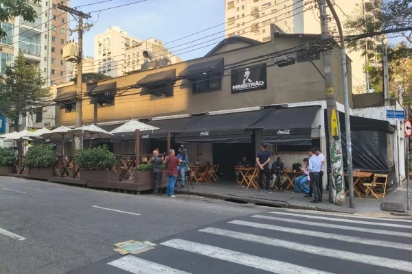 Imagens coloridas mostram fachada de mar, com placa com os dizeres "Ministrão" no alto, pessoas sentadas em mesas do lado de fora, na calçada