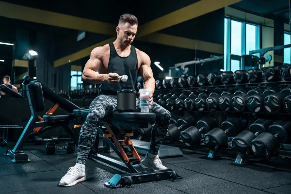 Foto colorida de homem tomando creatina na academia - Metrópoles
