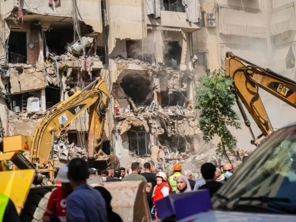 Foto colorida de equipes de resgate vasculhando escombros em local de um ataque israelense - Metrópoles