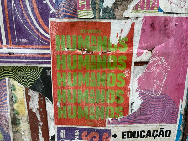 Imagem colorida mostra cartaz sobre direitos humanos em centro de acolhimento a imigrantes