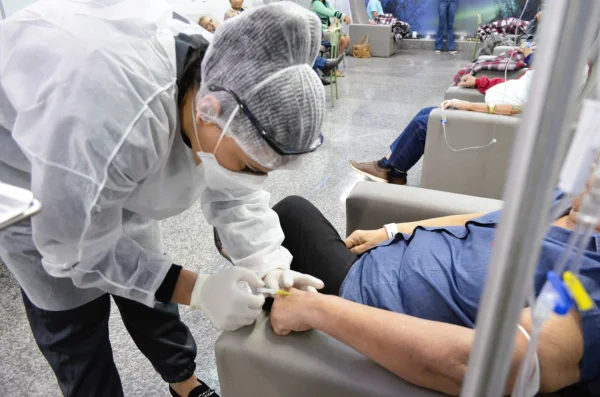 Fotografia colorida mostrando médica inetando remédio em paciente-Metrópoles
