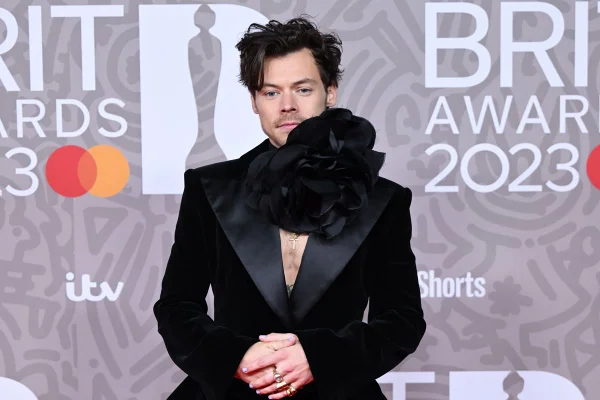 Harry Styles usa terno preto e choker de flor preta gigante no pescoço - Metrópoles