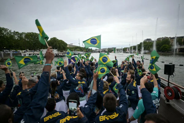 PARIS, FRANÇA - 26 DE JULHO: Atletas da delegação brasileira agitam bandeiras brasileiras enquanto navegam em um barco ao longo do rio Sena durante a cerimônia de abertura dos Jogos Olímpicos Paris 2024, em 26 de julho de 2024, em Paris, França