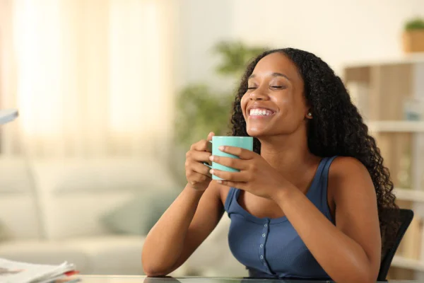 foto colorida de mulher negra feliz tomando chá