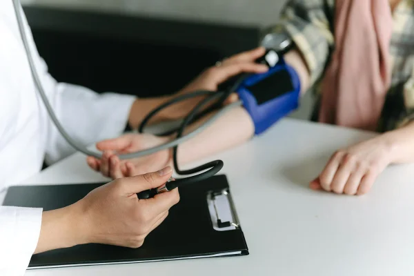 Mãos de médica medindo a pressão de paciente - Médicos apontam piores alimentos para quem tem pressão alta - Metrópoles