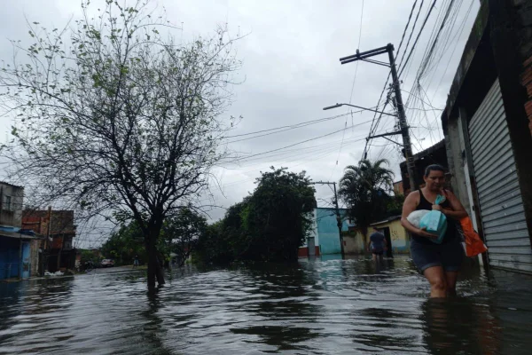 Imagem colorida de uma mulher andando pelas ruas alagadas do bairro Jardim Pantanal, na zona leste de SP - Metrópoles