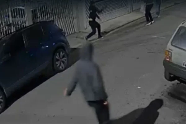 Foto colorida de vídeo em que mostra momento que bandidos tentam abordar policial civil e atiram contra ele. Esposa da vítima presenciou o crime.