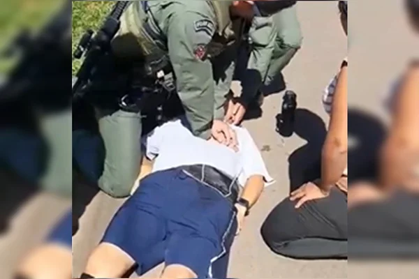 homem caído no chão e PM fazendo massagem cardíaca