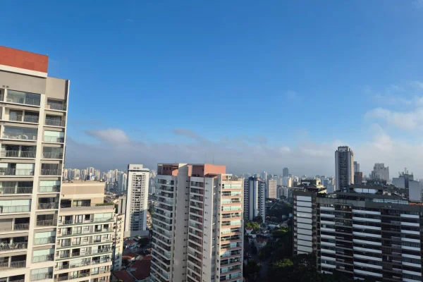 Imagem colorida mostra céu azul com algumas nuvens em tom marrom no horizonte - Metrópoles