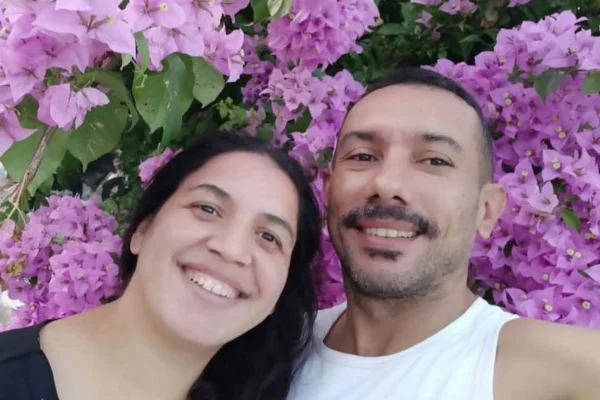 Foto colorida de um casal com decoração de flores atrás. Homem matou mulher a socos na Praia Grande, litoral sul de São Paulo.
