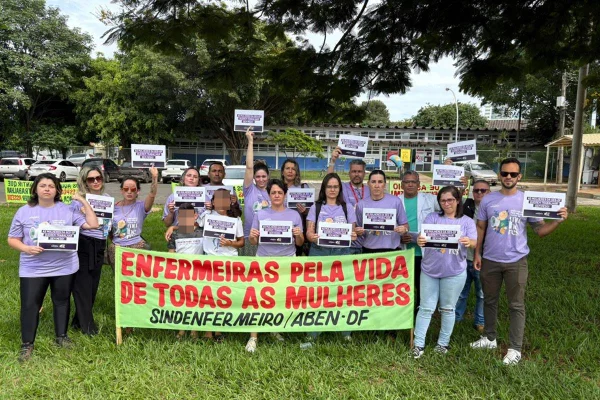 Foto manifestantes em frente a porta de Unidade Básica de Saúde