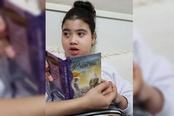 Criança segura livro da pequena sereia