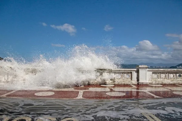 foto colorida de ressaca em praia de Santos, mostra água do mar avançando para a calçada - Metrópoles
