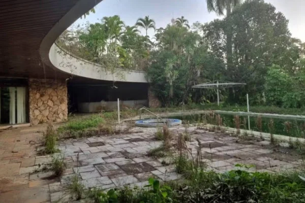 Imagem colorida de interior de mansão abandonada. Metrópoles