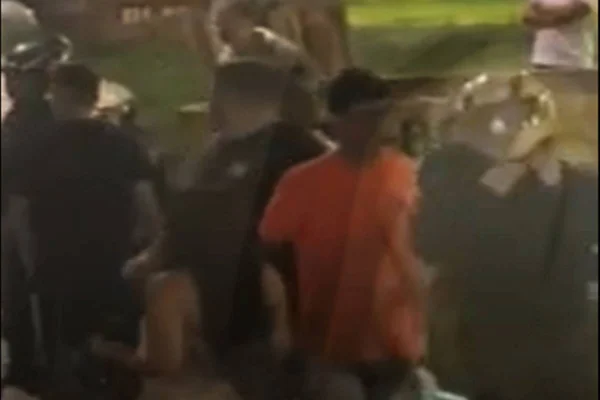 Foto tirada à noite destacando homem de capacete e moletom preto