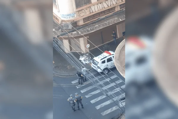 Imagem colorida de policiais militares próximos ao corpo do homem em situação de rua morto baleado - Metrópoles