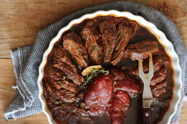 Na foto, uma carne cortada com molho marrom