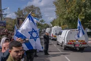 israelenses agitam a bandeira nacional e se reúnem ao longo da estrada enquanto o comboio de veículos transportando os corpos da familia Bibas entregues pelo Hamas, chega ao Centro Nacional de Medicina Forense em Tel Aviv israelenses agitam a bandeira nacional e se reúnem ao longo da estrada enquanto o comboio de veículos transportando os corpos da familia Bibas entregues pelo Hamas, chega ao Centro Nacional de Medicina Forense em Tel Aviv
