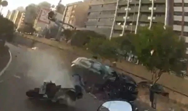 Imagem colorida mostra homem projetado no ar, carro e moro colididos, em avenida - Metrópoles