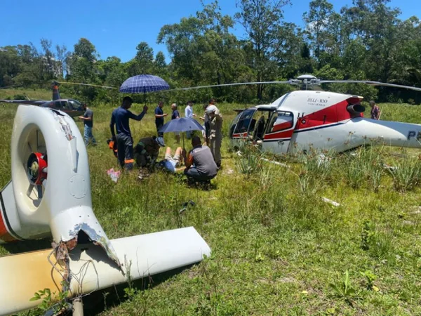 Helicóptero destruído após queda no Rio de Janeiro, em meio ao mato. Ele carragava cinco pessoas e na imagem é possível vez vários socorristas atendendo vítimas - Metrópoles