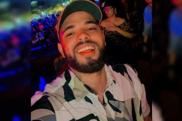 homem com blusa branca com preto sorrindo