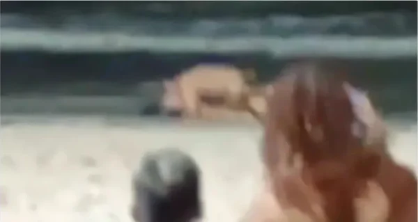 Foto colorida e borrada do policial na praia - Metrópoles