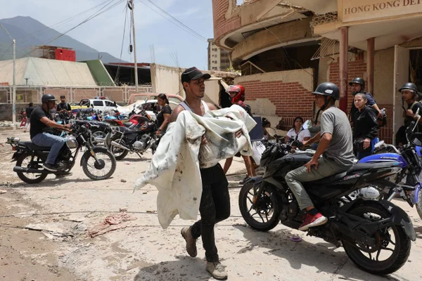 Homem segura uma vítima após terremoto de magnitude 7,2 atingir a Venezuela