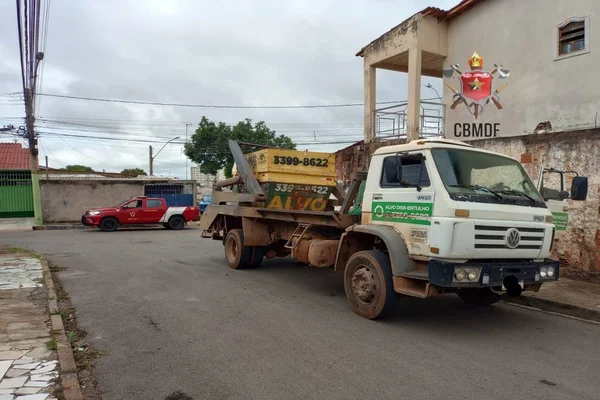 imagem colorida. Caminhão de entulho estacionado em frente à casa
