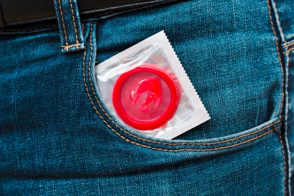Foto colorida de camisinha em bolso
