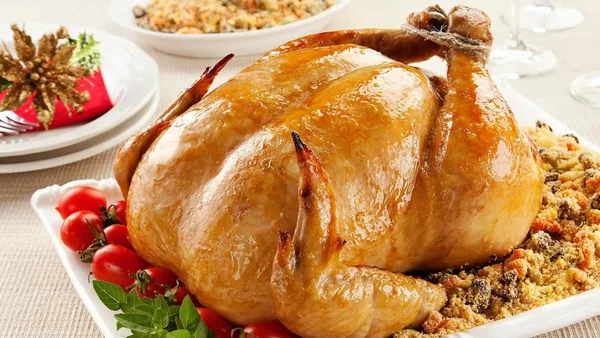 Frango assado recheado com farofa úmida e aromática para o Natal