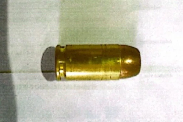 Imagem colorida de munição de arma de fogo. Imagem mostra uma bala sobre superfície plana -Metrópoles