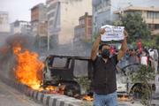 Um manifestante exibe cartazes em desafio durante um protesto contra a corrupção e a proibição das redes sociais em Catmandu, Nepal, em 8 de setembro de 2025.