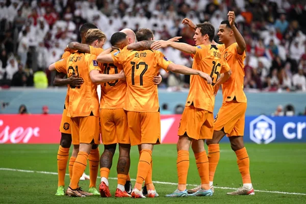 Seleção da Holanda comemora gols contra Catar em campo na Copa do Mundo do Catar. Eles usam uniforme laranja - Metrópoles