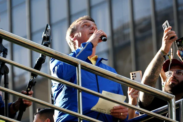 Jair Bolsonaro em manifestação Avenida na Paulista. Vestido de azul, ele segura um microfone e olha para cima - Metrópoles