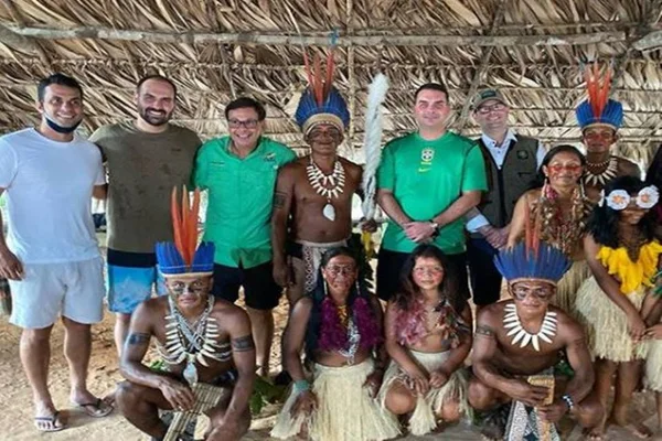 Sem máscaras, Flávio e Eduardo Bolsonaro tiram fotos ao lado de indígenas