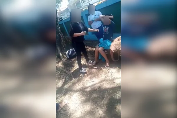 criança sentada em banco e outras duas em pé