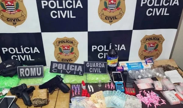 Mesa com objetos apreendidos, entre eles: tijolos de maconha, embalagens de entorpecente, notas de dinheiro e caderno de anotações - Metrópoles