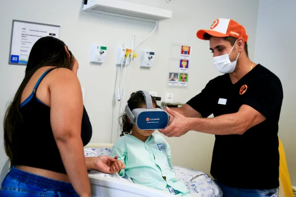 Homem segura óculos de realidade virtual para menina