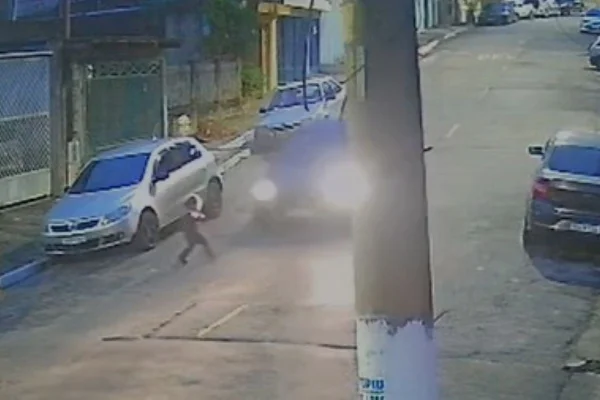 Criança vê carro se aproximar com faróis dianteiros ligados no meio da rua - Metrópoles