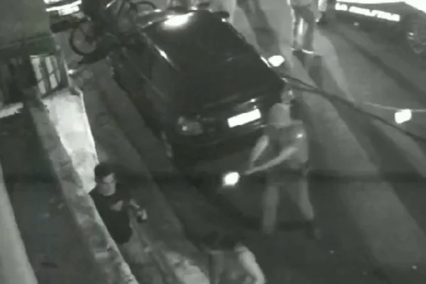 Imagem em preto e branco de um policial militar efetuando disparo de arma de fogo. Homem foi baleado - Metrópoles