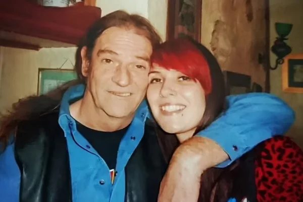 Foto de homem com roupa azul abraçado com jovem de cabelo vermelho - Metrópoles